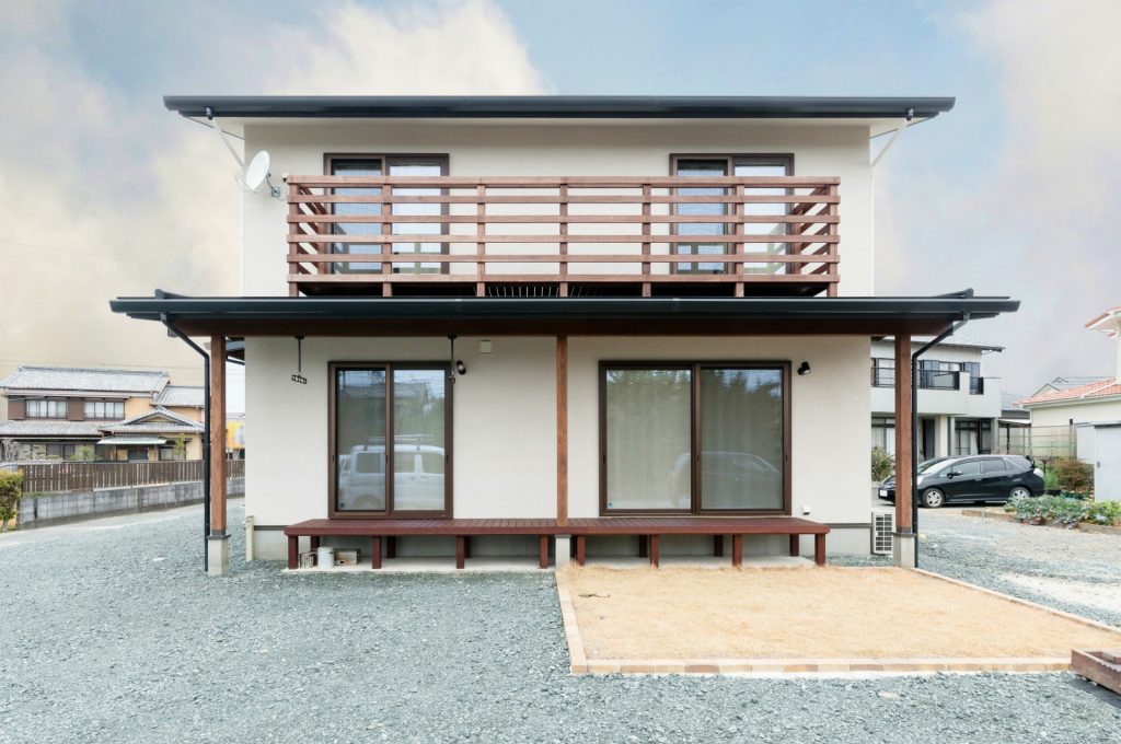 木製ベランダと塗り壁の自然素材住宅