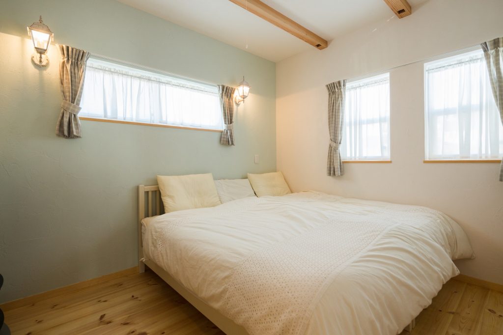 ぐっすり眠れる寝室。一面だけ色をかえた青い塗り壁と照明が奥様のこだわり