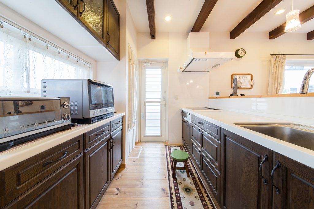 キッチン扉と、天井の梁のカラーを合わせて一体感のある空間に