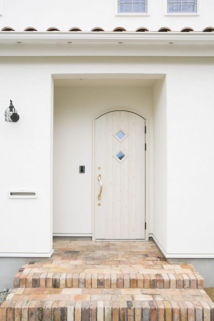 天面が弧を描く白い木製ドアが可愛らしくロマンチックな雰囲気