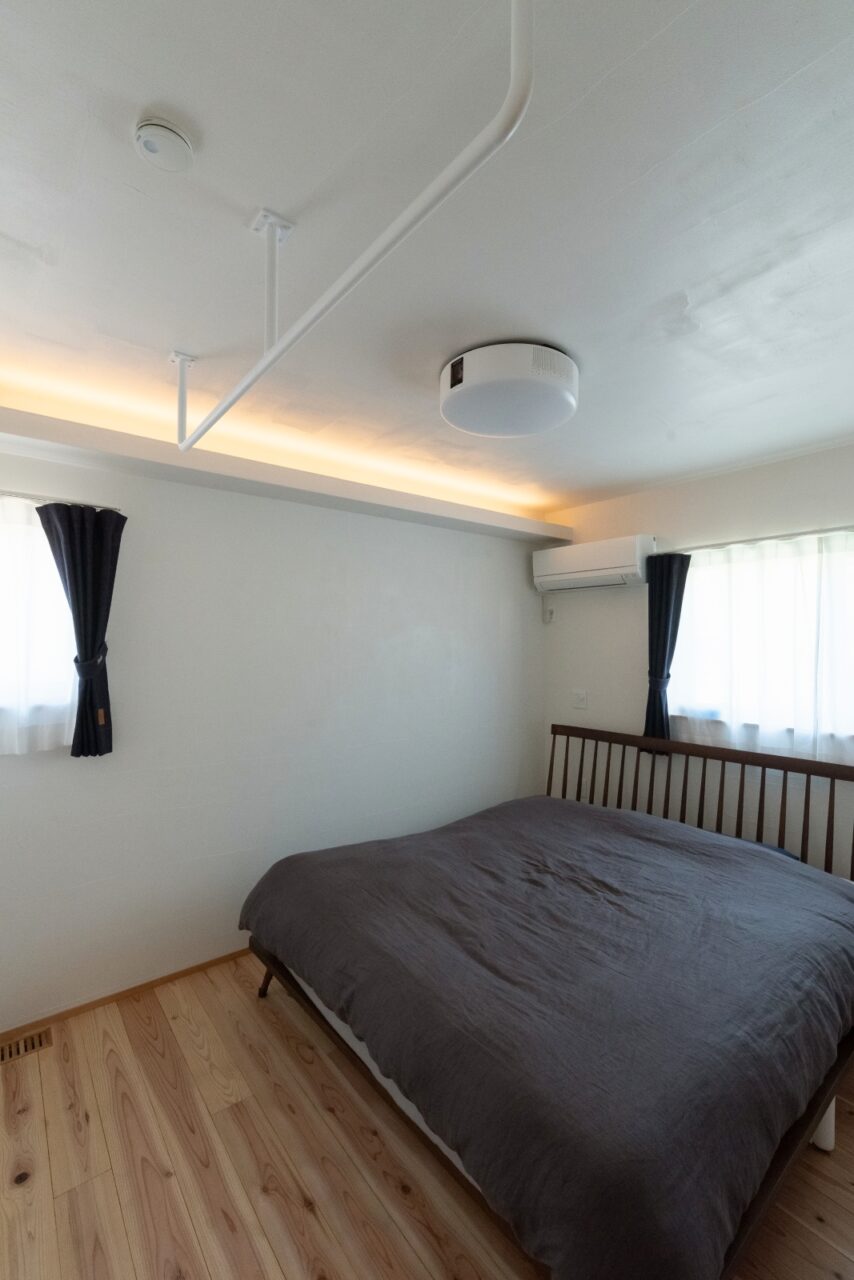 懸垂バーとプロジェクターのあるシンプルな寝室