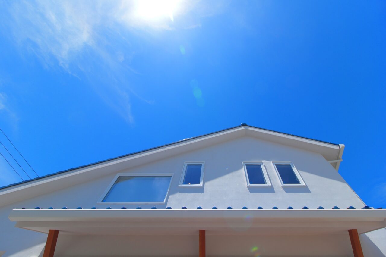 青空に白が映える大屋根の家