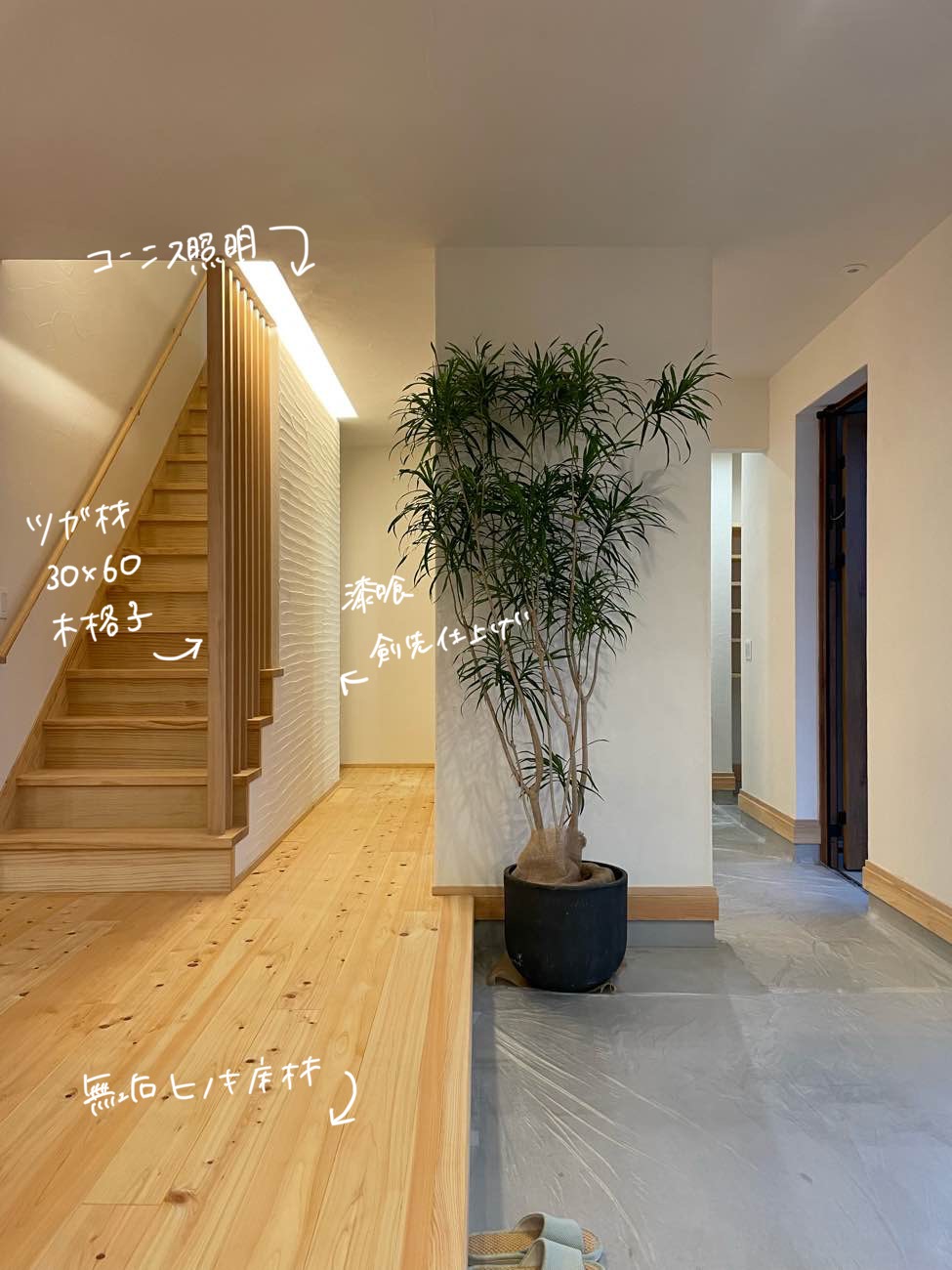 自然素材新築住宅の広い玄関土間と階段の木格子