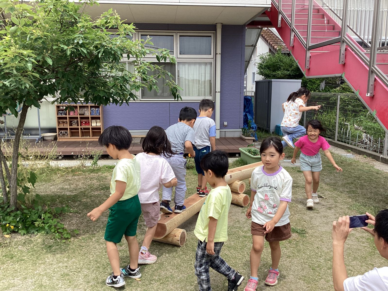 寄贈した丸太の遊具で遊ぶ園児たち