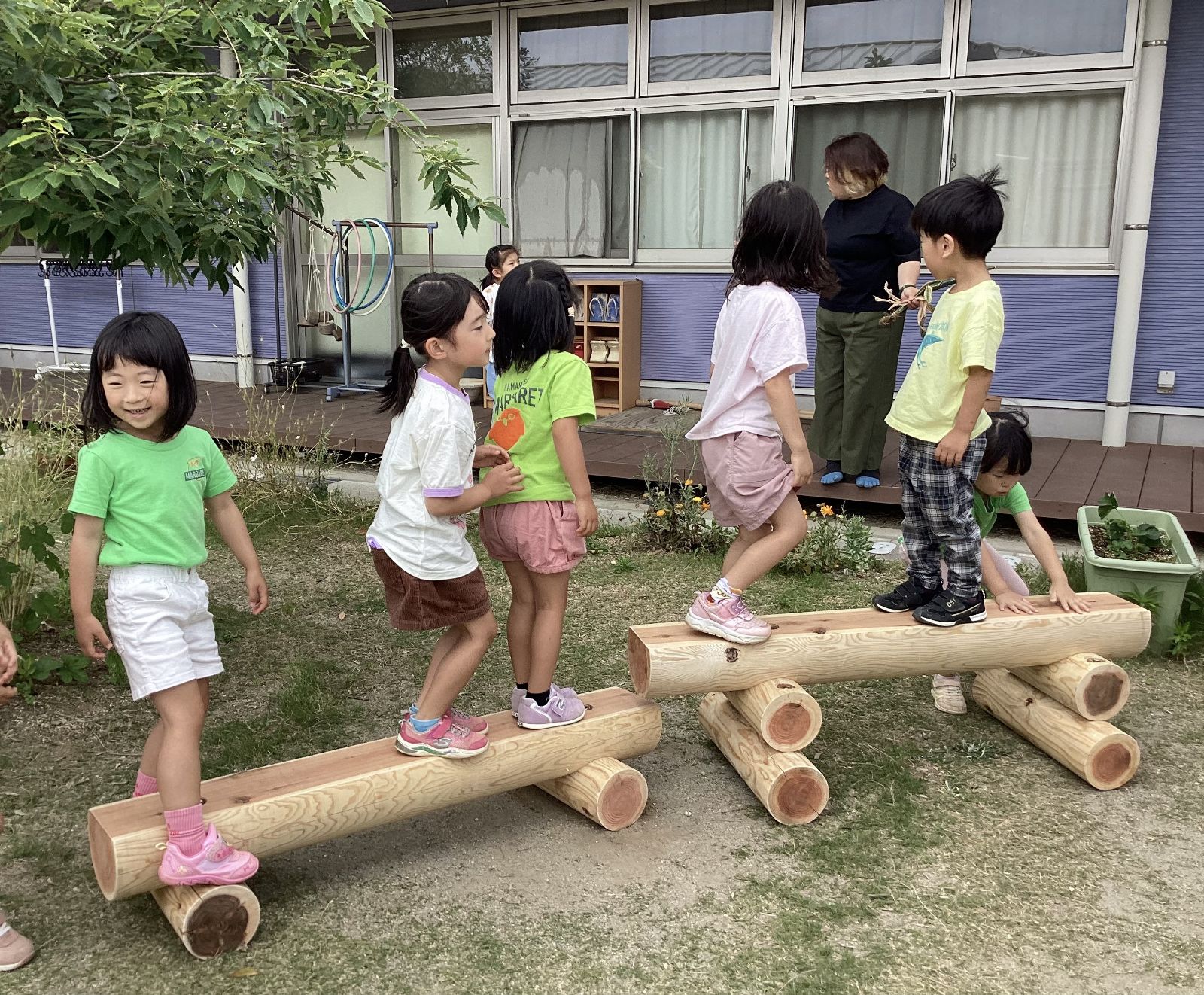 寄贈した丸太の遊具で遊ぶ園児たち