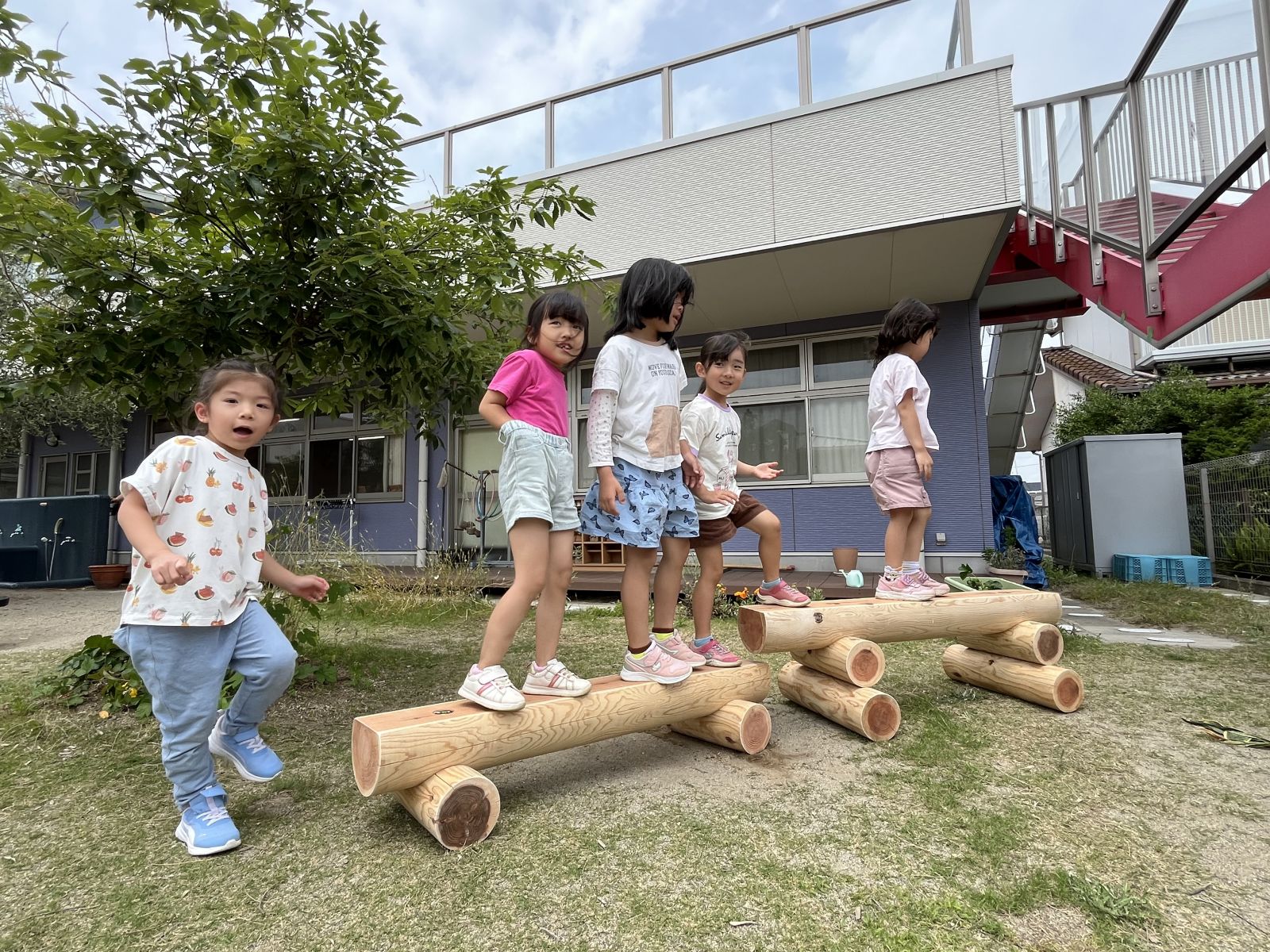 寄贈した丸太の遊具で遊ぶ園児たち