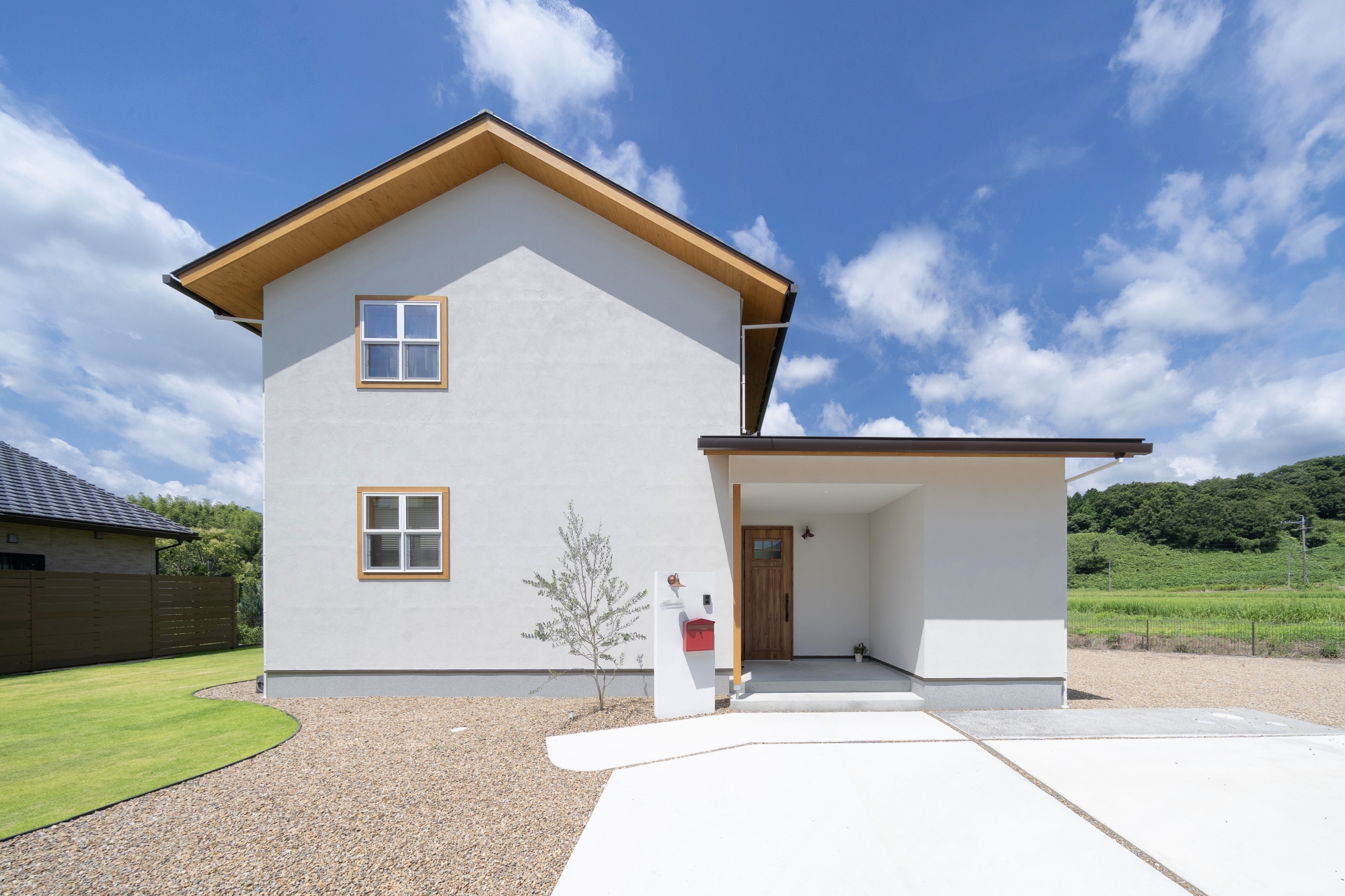 大人可愛い北欧風の外観、三角屋根と正方形の窓と白色の塗り壁か自然の景色と調和する絵本にでてくるような家